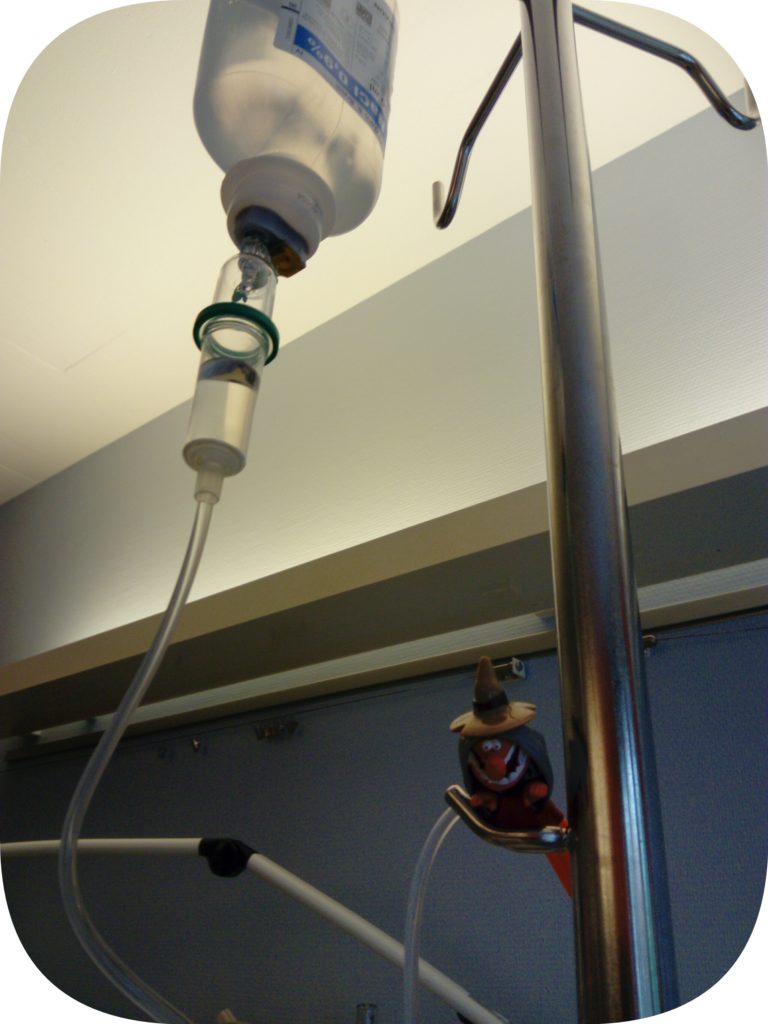 Anna Füller Xi, die personifizierte Anaphylaxie beobachtet vom Infusionsständer aus die Provokation